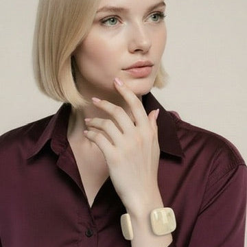 Woman wearing a burgundy shirt with a beige background