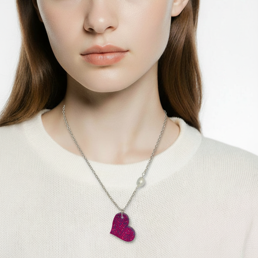 Woman wearing a necklace with a heart-shaped pendant on a plain background
